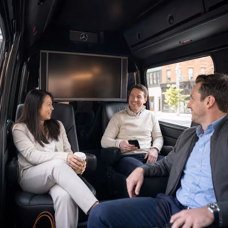 Group boarding a white charter bus for Corporate Transportation transportation in Brooklyn