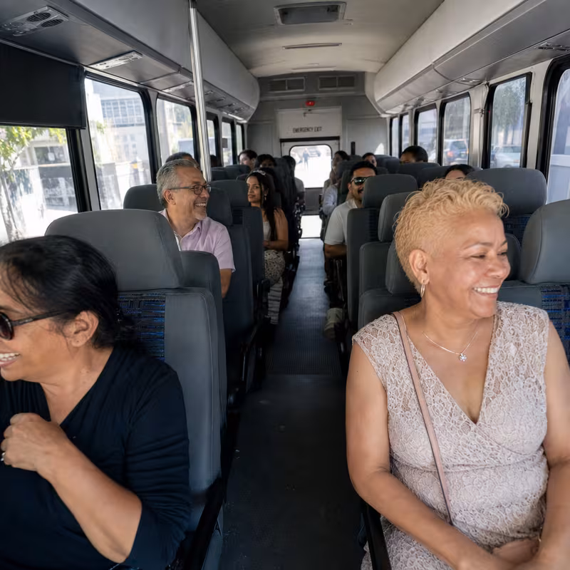 Group boarding a white charter bus for Private Event Transportation transportation in Brooklyn
