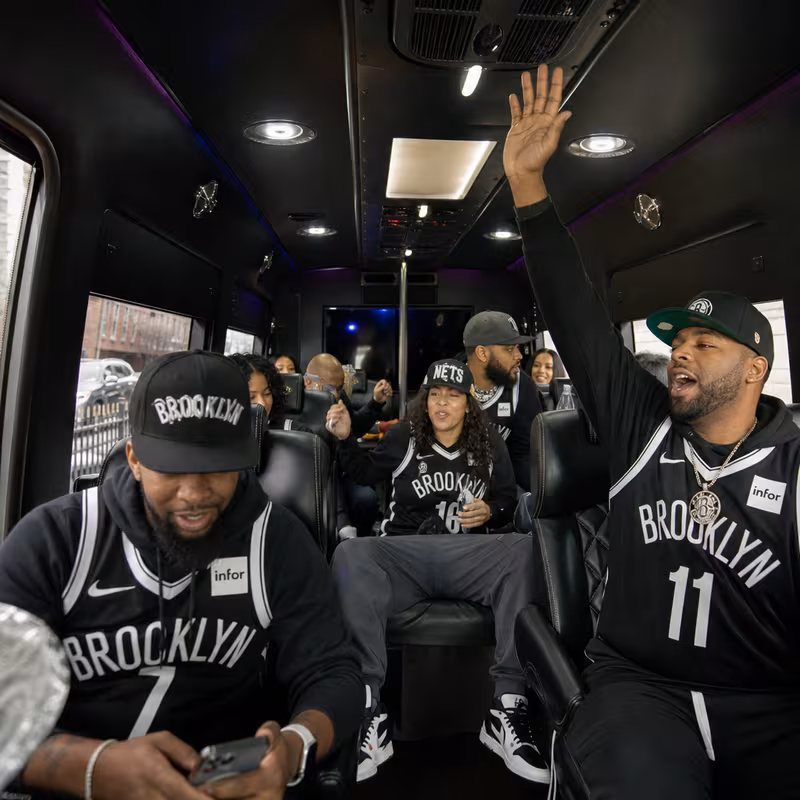 Group boarding a white charter bus for Sporting Event Transportation transportation in Brooklyn