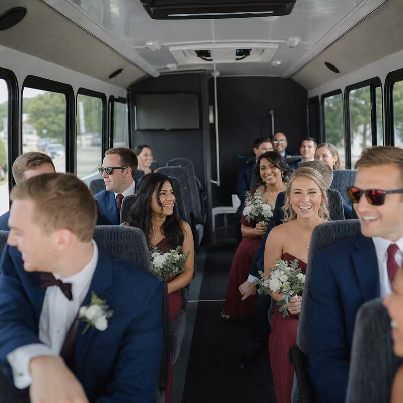 Group boarding a white charter bus for Wedding Transportation transportation in Brooklyn